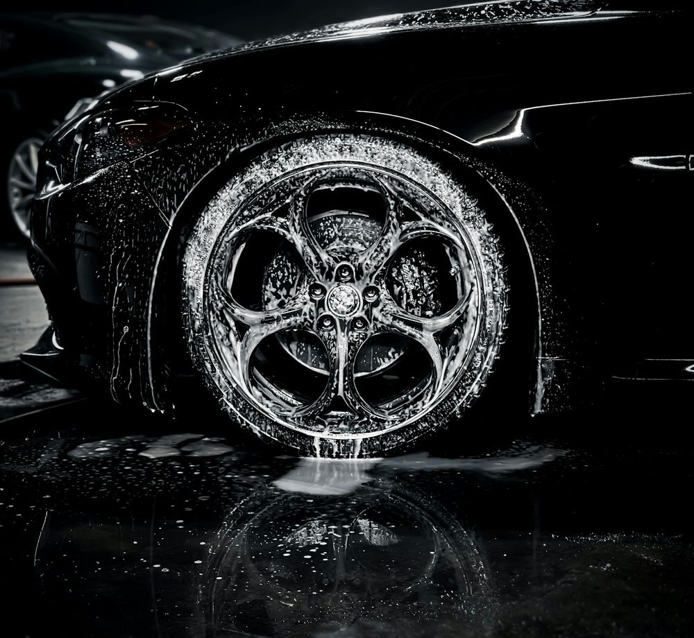 Close-up of a freshly detailed, foam-covered alloy wheel
