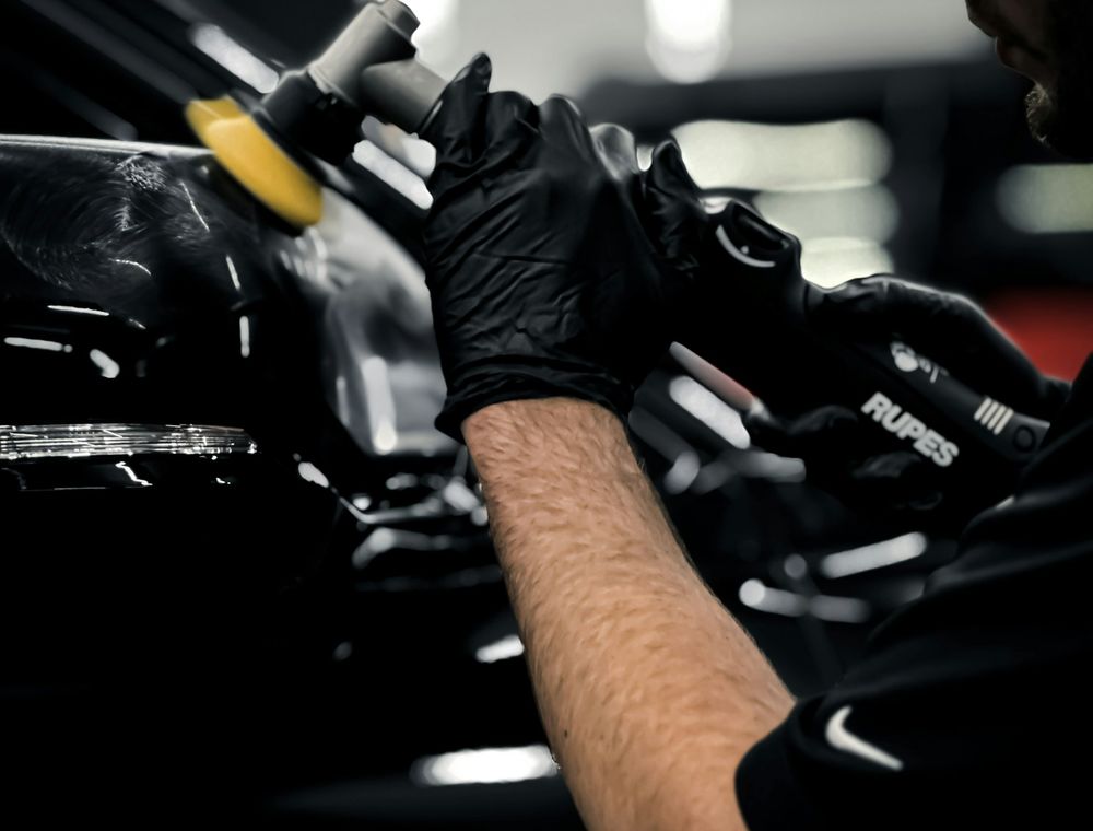 Detailer machine-polishing a car panel